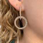 Gold double loop earrings with pave cubic zirconia in ear.