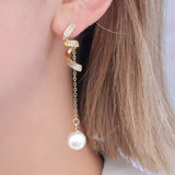 Ribbon earrings with CZ embellishments connected to a chain with a gorgeous pearl on the end being worn