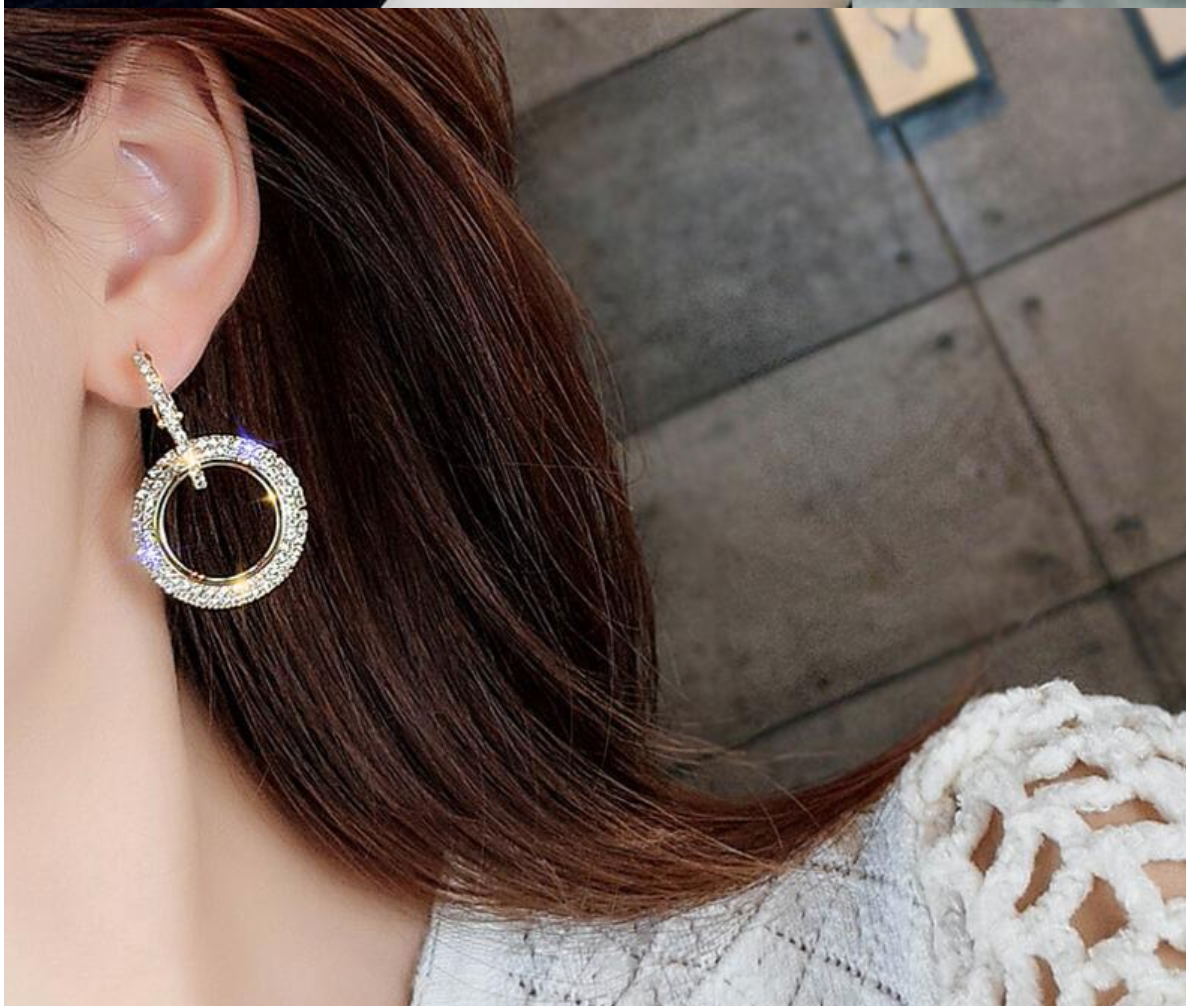Gold double loop earrings with pave cubic zirconia in ear.